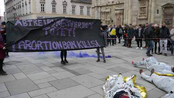 Foto: Transparent Abortionban kills! mit blauem Pyro im Hintergrund
